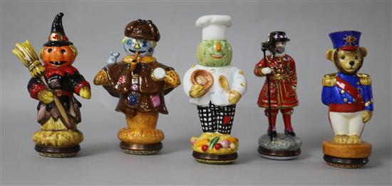 Five Halcyon Days Enamels bonbonnieres modelled as scarecrows and two others.